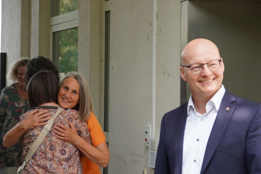 Menschen, die sich in der Nähe des Eingangs umarmen.