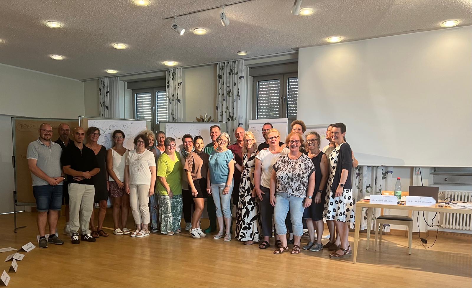 Seminargruppe lächelt für das Gruppenfoto in die Kamera.